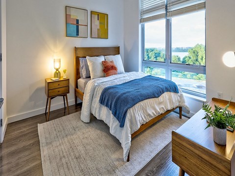 a bedroom with a bed and a large window